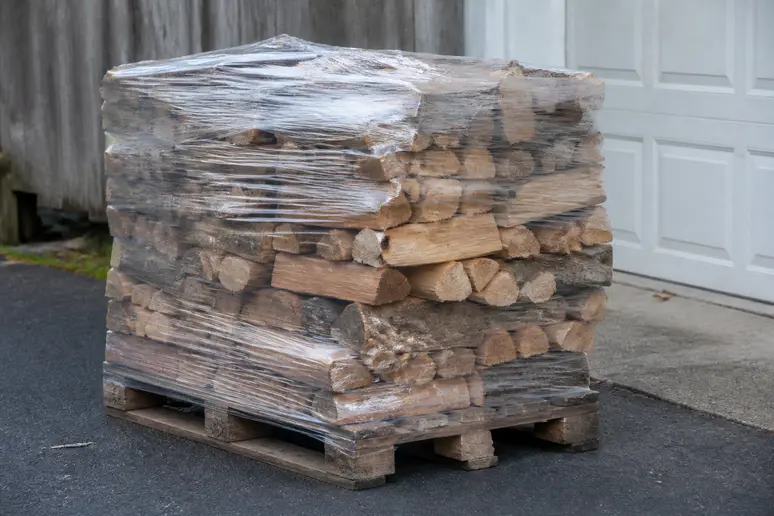 Palette de bois de chauffage livrée à domicile dans une cour à Metz
