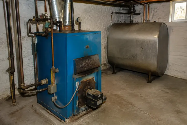 Cuve et chaudière au fioul dans un sous-sol de maison pour illustrer la facture énergétique.