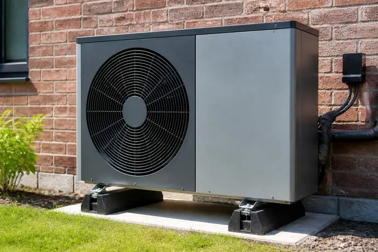 Unite exterieure de pompe a chaleur installee sur un mur exterieur de maison
