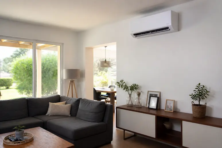 Unité intérieure de climatisation réversible installée au mur dans un salon lumineux