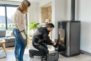 Un technicien qualifié effectue la maintenance d'un poêle à granulés Lorraine dans un salon lumineux