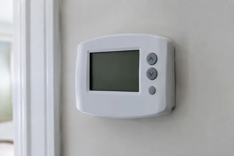 Boîtier de thermostat d'ambiance numérique fixé sur un mur intérieur pour le réglage du chauffage