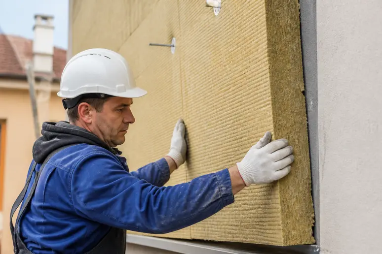 Artisan RGE posant des panneaux d'isolation thermique pour un projet de rénovation énergétique en Lorraine