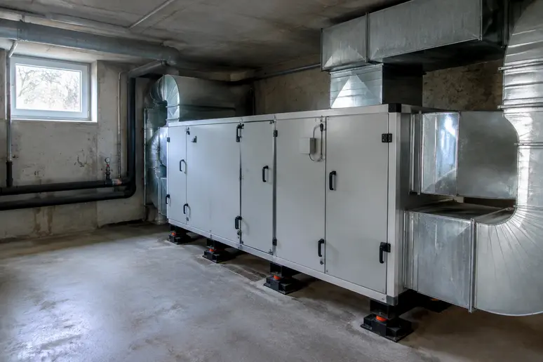 Caisson de VMC collective installé dans un local technique de copropriété